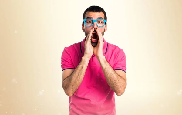 Man with colorful clothes shouting on ocher background — Stock Photo, Image