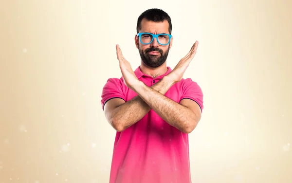 Muž s barevné oblečení dělat žádné gesto na okrové pozadí — Stock fotografie