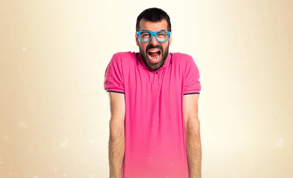 Homme frustré avec des vêtements colorés sur fond ocre — Photo
