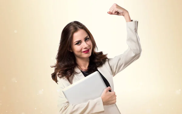 Suerte bastante joven mujer de negocios con ordenador portátil en ocre backgroun —  Fotos de Stock