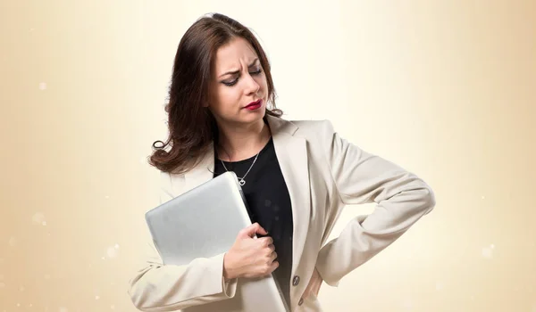 Mujer de negocios bastante joven con portátil sobre fondo ocre —  Fotos de Stock