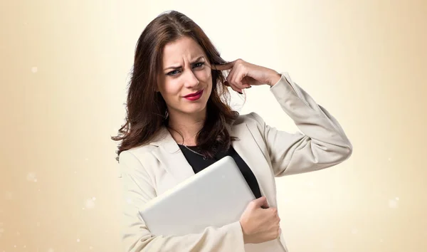 Dość młoda kobieta z laptopa i obejmujące jego uszy na — Zdjęcie stockowe