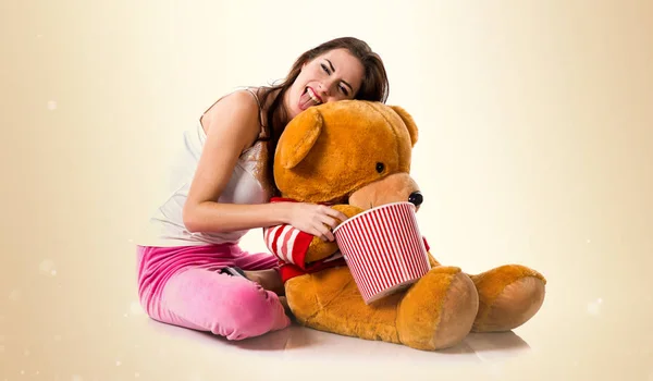 Boldog lány pizsama és a gazdaság egy tál popcorns, míg a pla — Stock Fotó