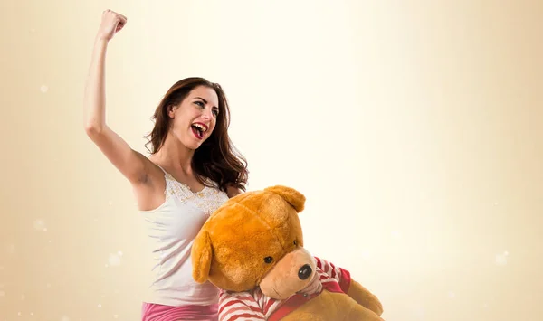 Lucky  girl with pajamas and playing with stuffed animal on oche — Stock Photo, Image