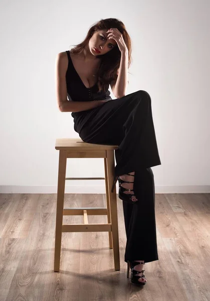 Το όμορφο μοντέλο γυναίκα κάθεται στην καρέκλα ξύλινη — Φωτογραφία Αρχείου