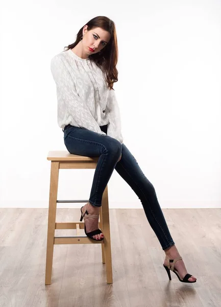 木製の椅子の上に座って美しいモデルの女性 — ストック写真