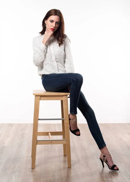 木製の椅子の上に座って美しいモデルの女性 — ストック写真