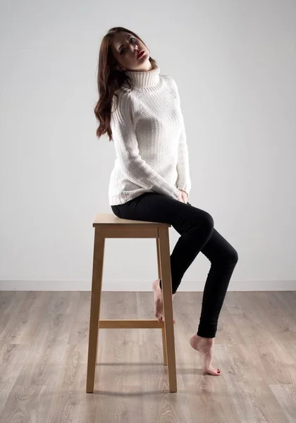 Beautiful model woman sitting on wooden chair — Stock Photo, Image