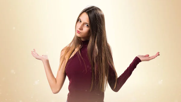 Junges Teenager-Mädchen macht unwichtige Geste auf ockerfarbenem Hintergrund — Stockfoto