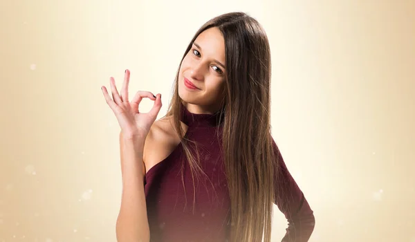 Junges Teenager-Mädchen macht ok Zeichen auf ocker Hintergrund — Stockfoto