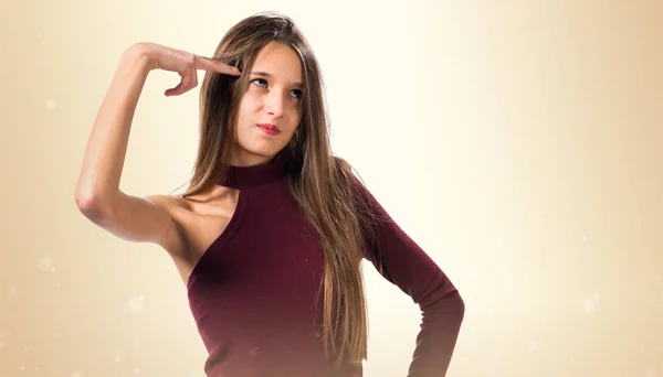 Young teenager girl making suicide gesture on ocher background — Stock Photo, Image