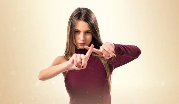 Young teenager girl making NO gesture on ocher background — Stock Photo, Image