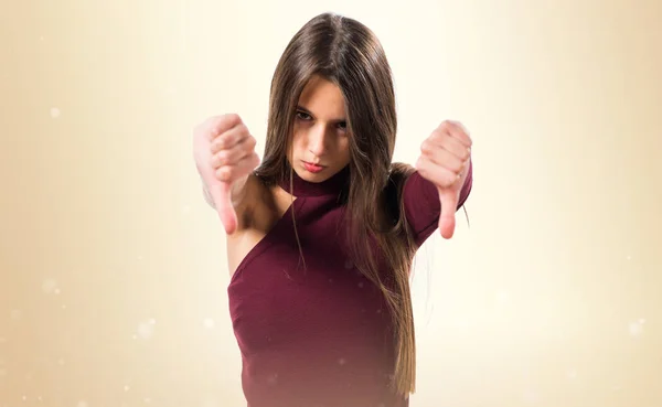 Chica haciendo mala señal en el fondo ocre — Foto de Stock