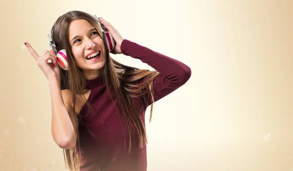 Mladá dospívající dívka poslech hudby na pozadí okrové — Stock fotografie