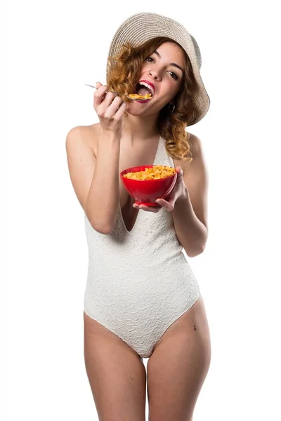 Hübsche junge Model-Frau im Badeanzug isst Müsli aus einer Schüssel — Stockfoto