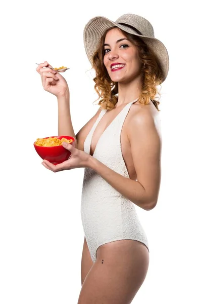 ボウルから穀物を食べて水着でかなり若いモデルの女性 — ストック写真