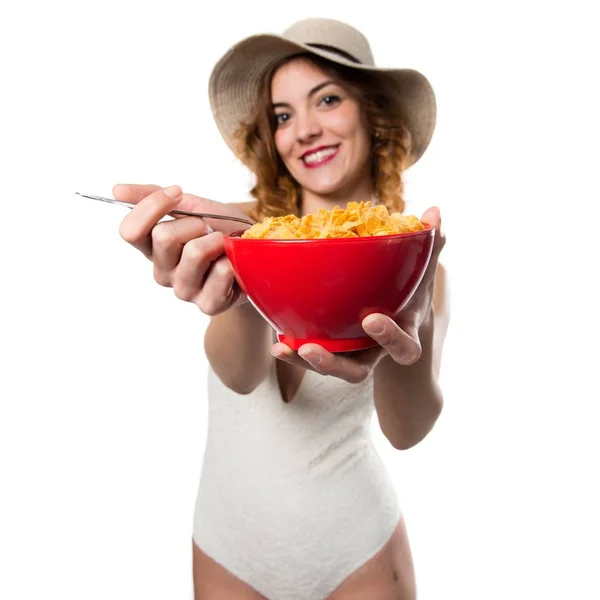 Mulher modelo muito jovem em maiô comendo cereais de uma tigela — Fotografia de Stock