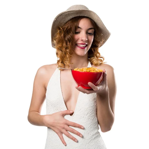 Bella giovane donna modello in costume da bagno mangiare cereali da una ciotola — Foto Stock