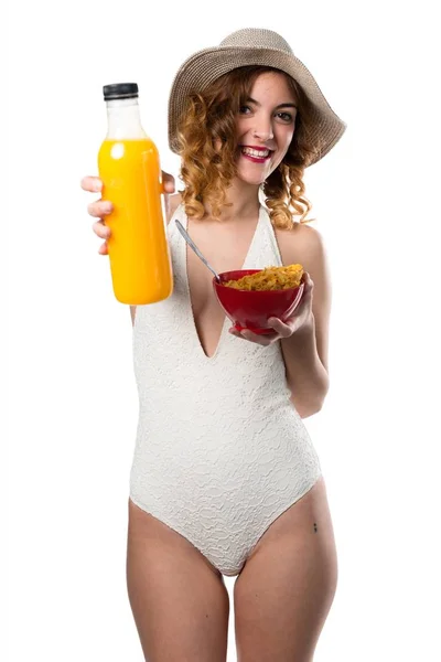 Mujer modelo bastante joven en traje de baño comiendo cereales y fruta naranja —  Fotos de Stock