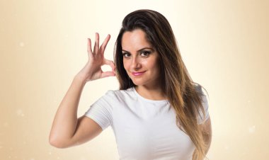 Genç güzel kız Tamam koyu sarı zemin üzerine kayıt yapma