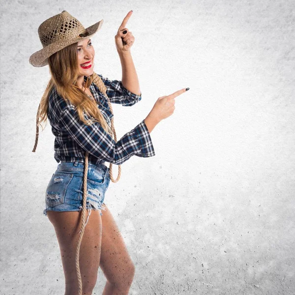 Sexy blonde Frau Cowgirl zeigt auf die seitliche — Stockfoto