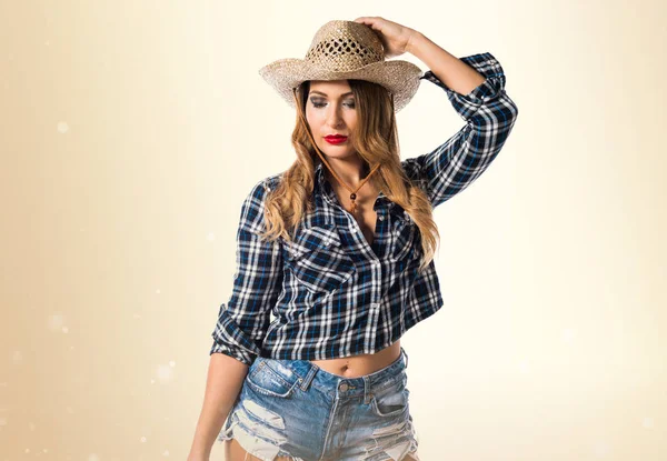 Sexy blondýnka cowgirl na okrové pozadí — Stock fotografie