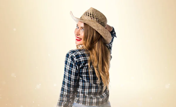 Sexy blondýnka cowgirl na okrové pozadí — Stock fotografie