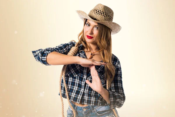 Sexy blondýnka cowgirl tvorby časový limit gesto na okrové backg — Stock fotografie