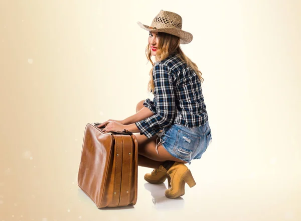 Sexy blonda femeie cowgirl cu vintage valiza pe ocher backgro — Fotografie, imagine de stoc