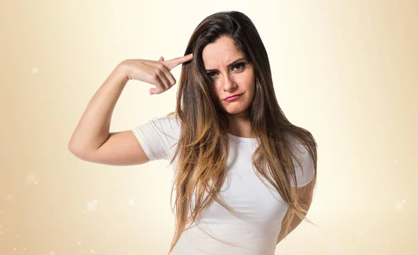 Young pretty girl making crazy gesture on ocher background — Stock Photo, Image