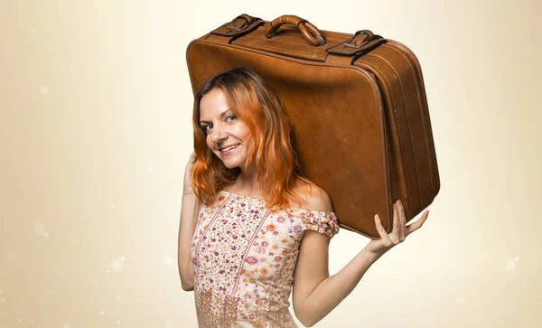 Bella donna con i capelli arancioni in possesso di una valigetta vintage su och — Foto Stock