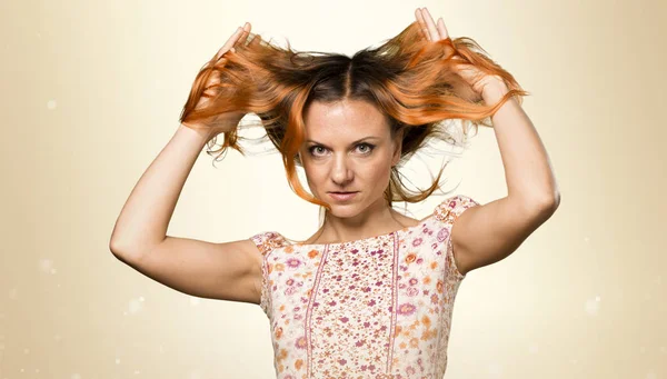 Pretty woman with orange hair on ocher background