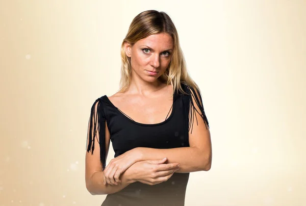 Orosz szőke nő fekete ruhás okker háttér — Stock Fotó