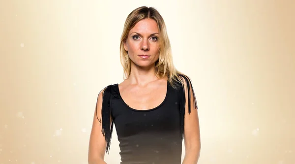 Ruská blondýnka žena v černých šatech na okrové pozadí — Stock fotografie