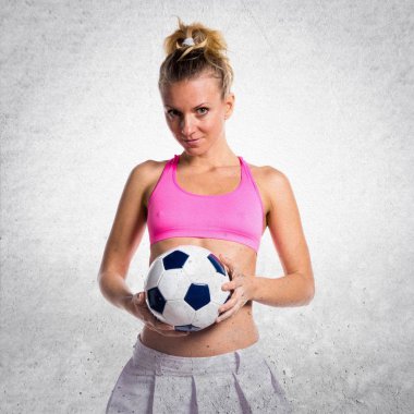 Güzel kız futbol oyuncu dokulu arka plan üzerinde