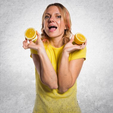 Limon dokulu arka plan üzerinde tutan güzel sarışın kadın