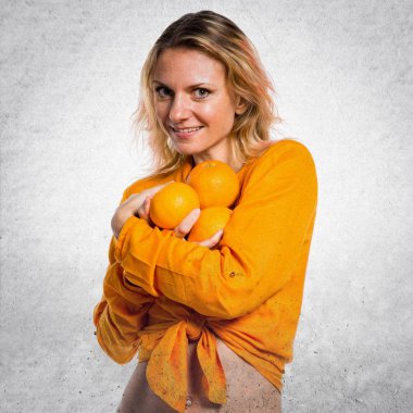 Portakal dokulu arka plan üzerinde tutan güzel sarışın kadın