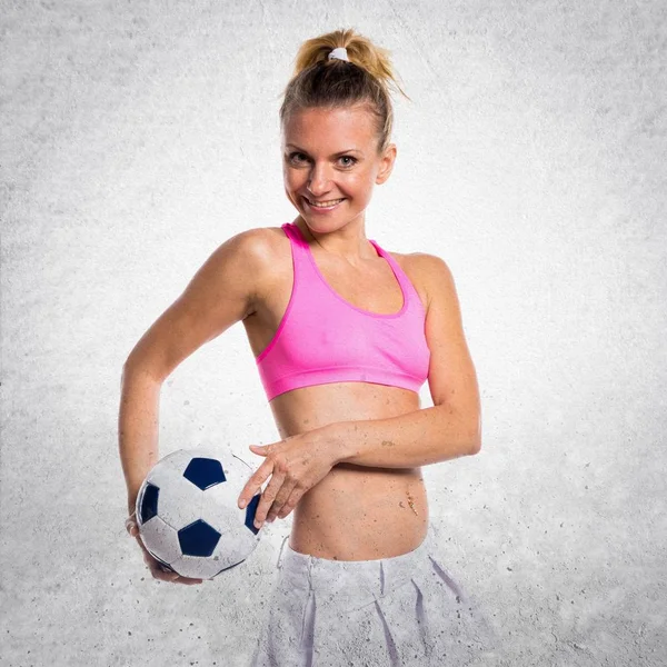 Gyönyörű lány foci játékos textúrázott háttérre — Stock Fotó