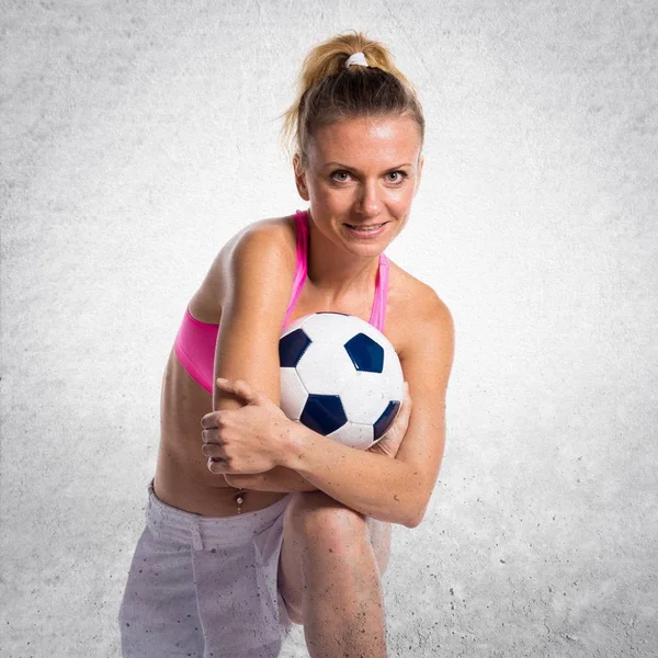織り目加工の背景に美しい少女フットボール選手 — ストック写真