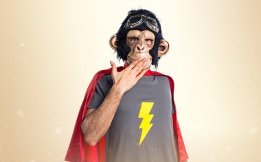 Süper kahraman maymun adam koyu sarı zemin üzerine sürpriz jest yapıyor