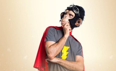 Süper kahraman maymun adam koyu sarı arka plan üzerinde düşünme