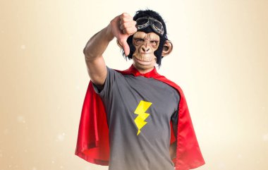 Süper kahraman maymun adam koyu sarı zemin üzerine kötü sinyal yapıyor