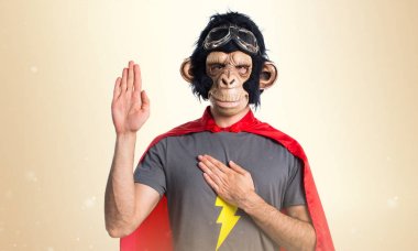 Süper kahraman maymun adam koyu sarı zemin üzerine yemin yapıyor