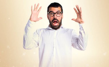 Koyu sarı zemin üzerine gözlük ile sinirli yakışıklı adam