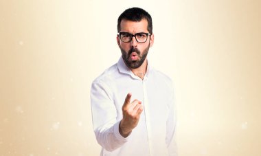 Kızgın yakışıklı adam bağırarak gözlük ve pounting koyu sarı b