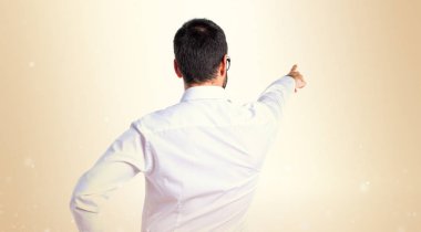 Yakışıklı adam gözlüklü koyu sarı zemin üzerine işaret