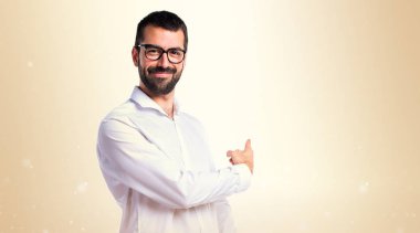 Yakışıklı adam gözlüklü koyu sarı zemin üzerine işaret