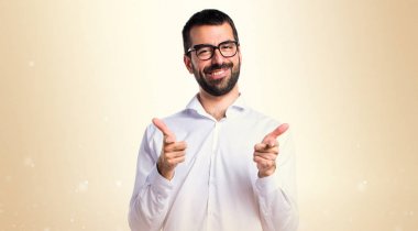 Gözlüklü lateral okra backg üzerinde işaret eden yakışıklı adam