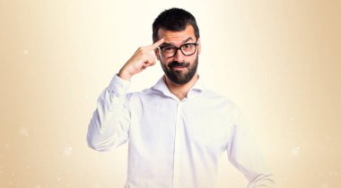 Koyu sarı arka plan üzerinde düşünme gözlüklü yakışıklı adam