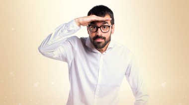 Bir şey Koyu sarı arka plan üzerinde gösterilen gözlüklü yakışıklı adam